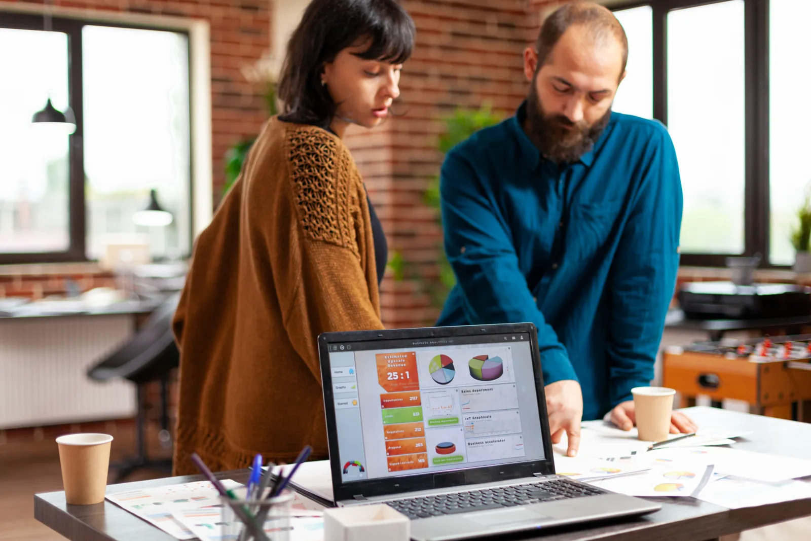 Businesspeople analyzing management documents discussing company strategy while brainstorming ideas business project startup office laptop computer with marketing data chart screen