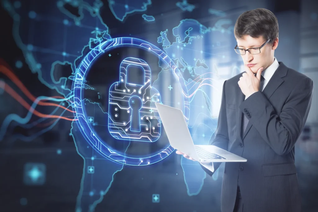 Attractive businessman using laptop with abstract digital padlock map hologram blurry office interior background security global protection concept double exposure